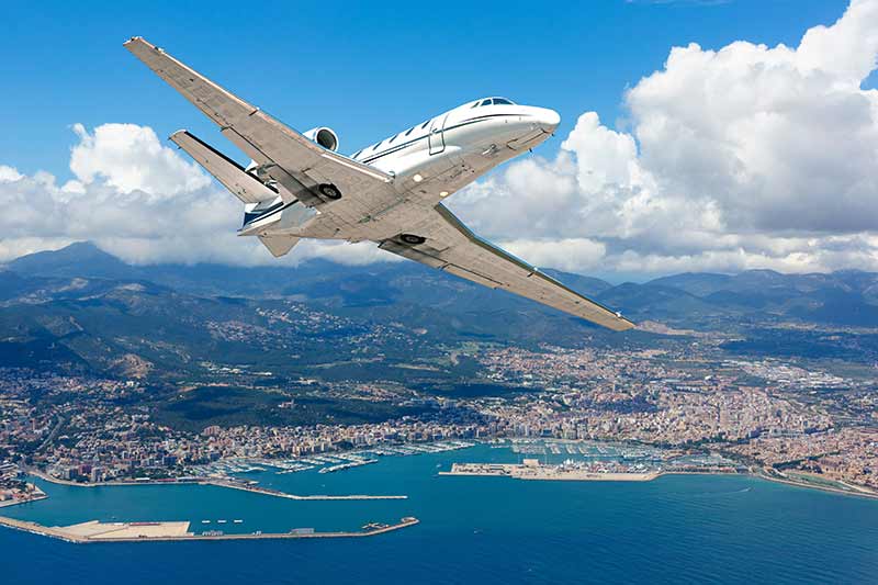 Private Jet flies over the coastline