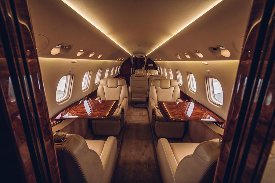 Interior Cabin of Luxury Private Jet Showing Comfortable Seats and Tables - Paramount Business Jets